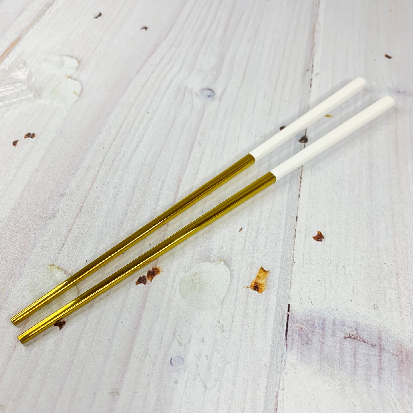 Par de palillos blanco con dorado (acero inoxidable)